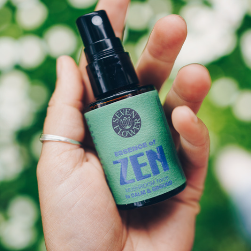 a hand holding a bottle of 7 Flower Essence of Zen
