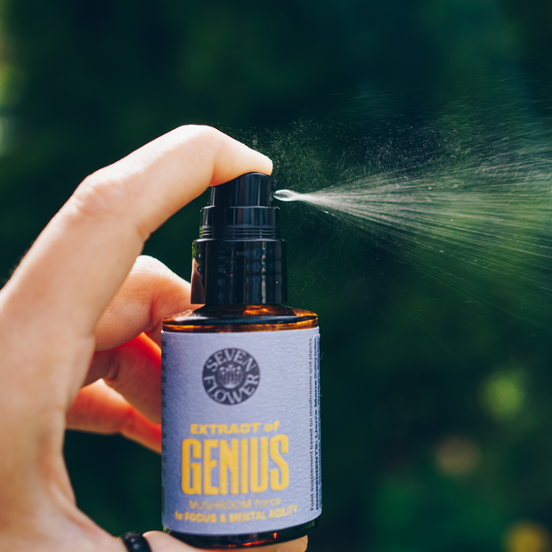 a hand spraying a bottle of 7 Flower Extract of Genius